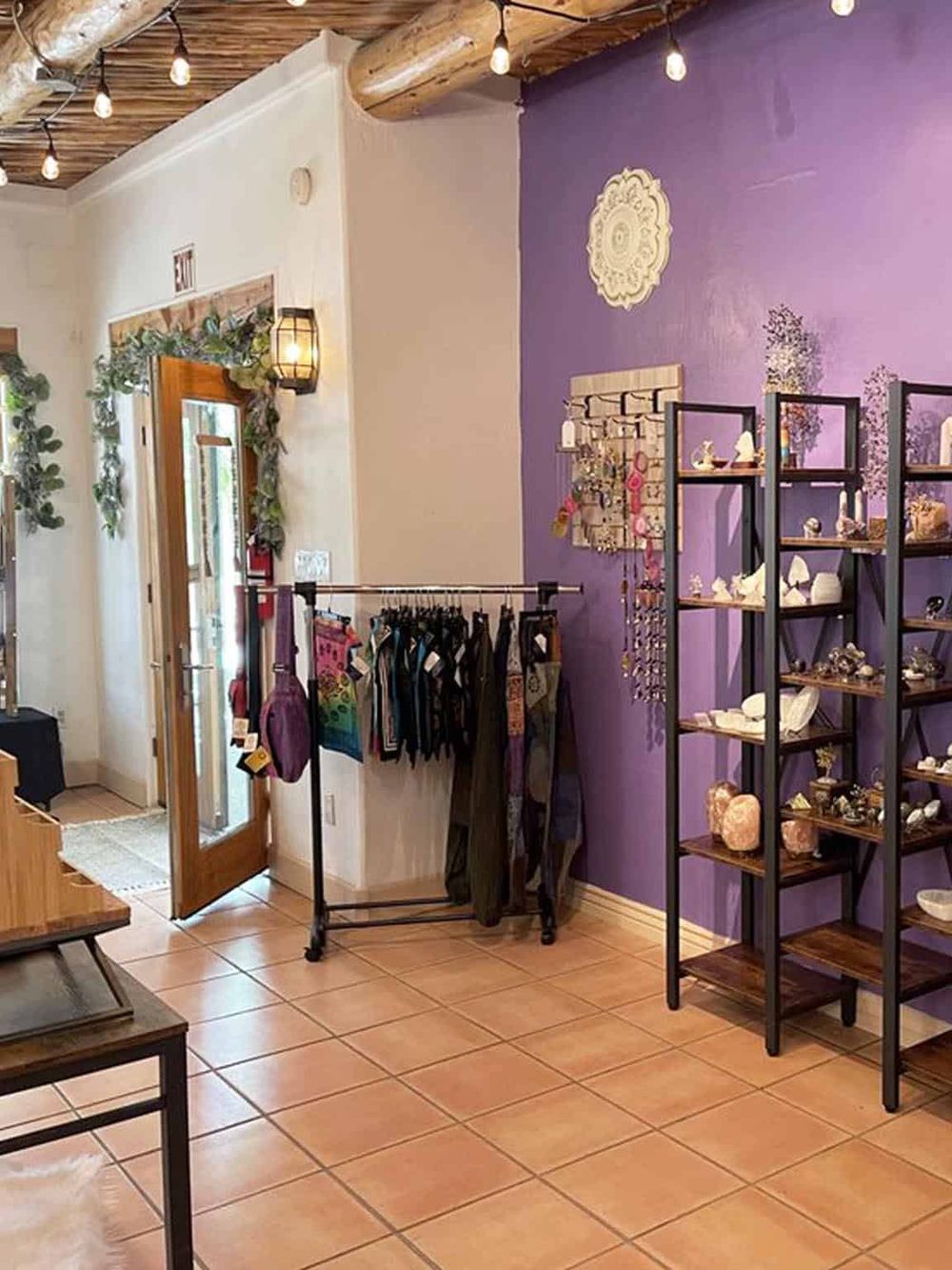 Coastal-inspired boutique with jewelry, accessories, and decor, featuring vibrant purple accent walls and rustic wooden accents.