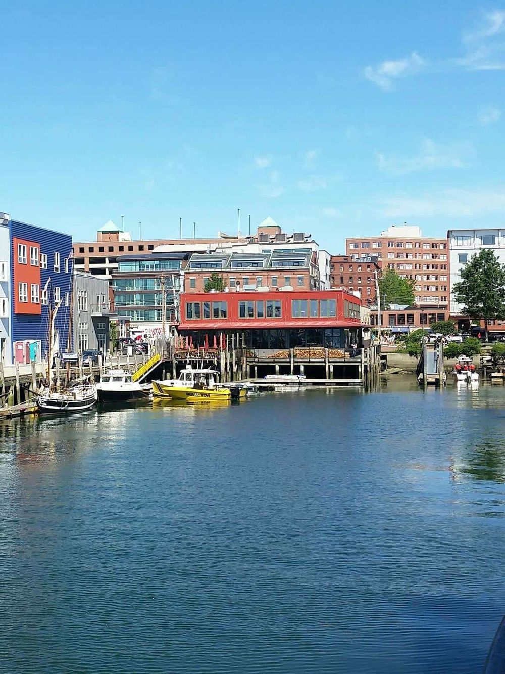 Colorful waterfront buildings with boats docked, emphasizing navigation and travel services.