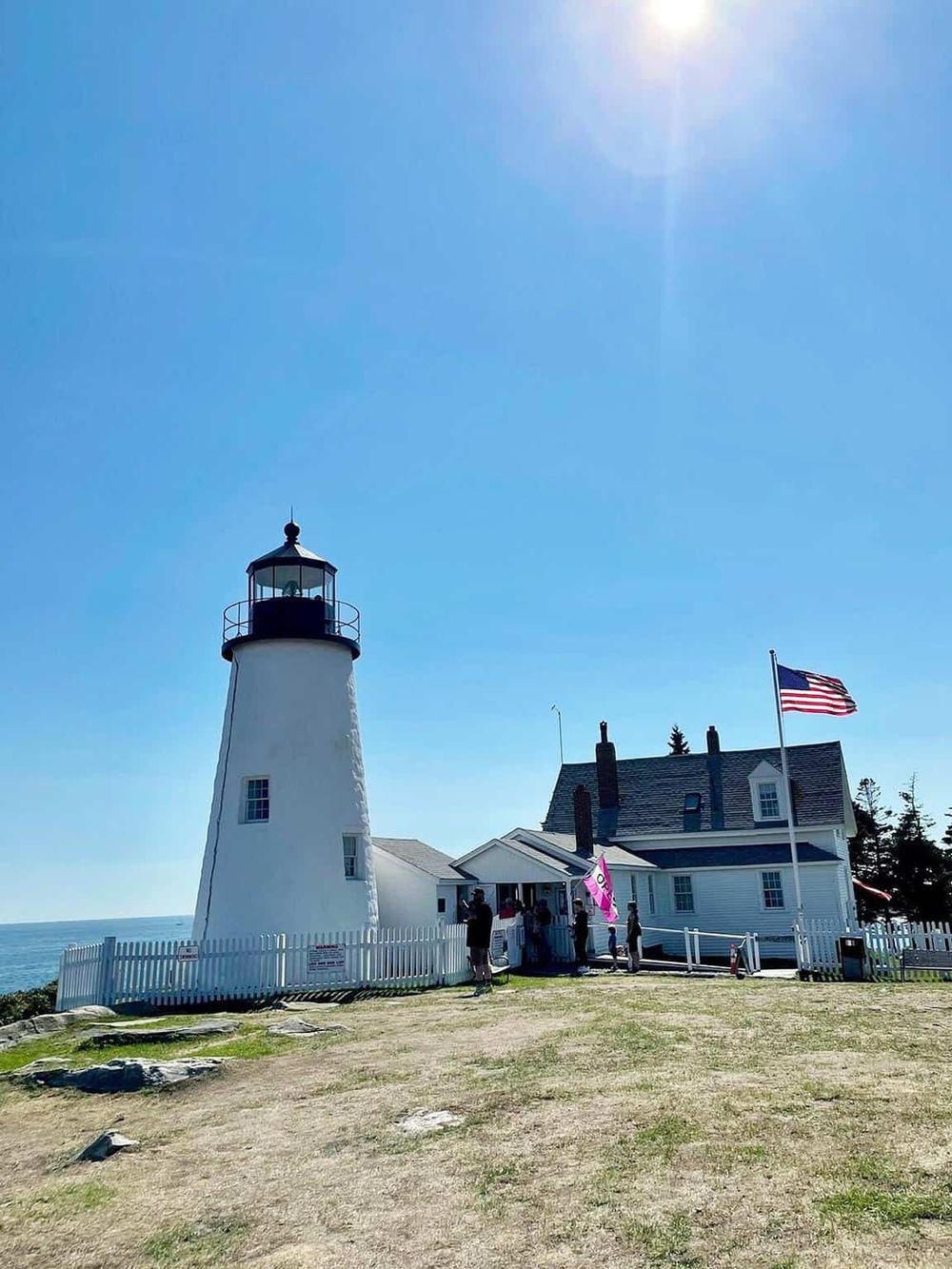 Lighthouse at Quest For Directions scenic coastal location, sunny sky, beach view.