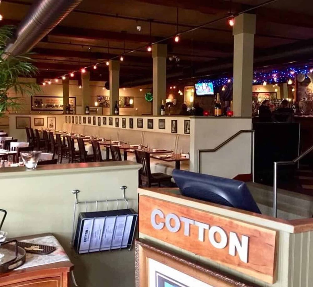 Cozy restaurant interior with festive string lights and bar area, perfect for a relaxing dining experience.
