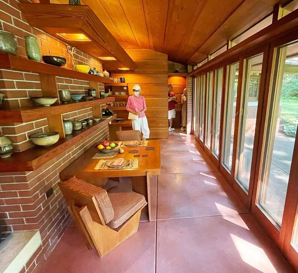 Warm wooden interior of a modern, eco-friendly home with large windows and stylish kitchen decor.