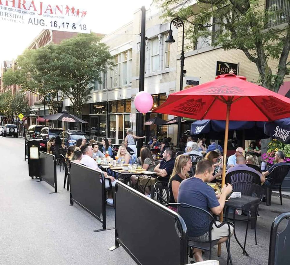 Enjoying outdoor dining at a bustling city street cafe in downtown.