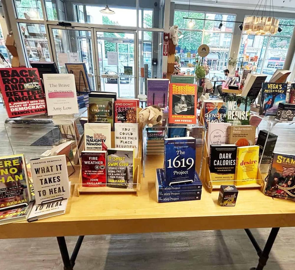Books on display at QuestForDirections bookstore exhibiting diverse titles and cozy reading environment.