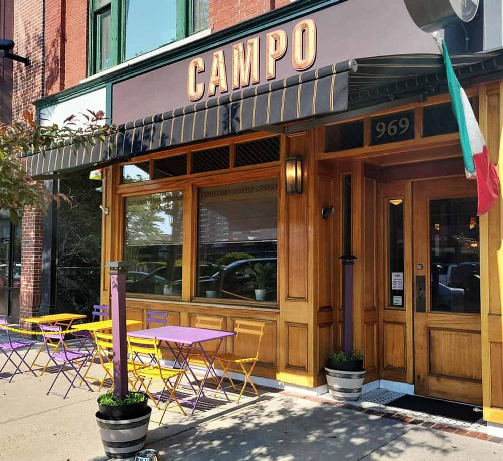 Charming restaurant with colorful outdoor seating and a wood-paneled facade, offering a delightful dining experience.