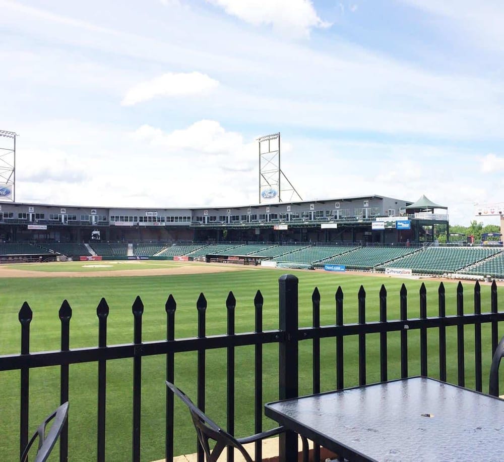 Empty baseball stadium with green field and seating, perfect for sports events and fan gatherings.