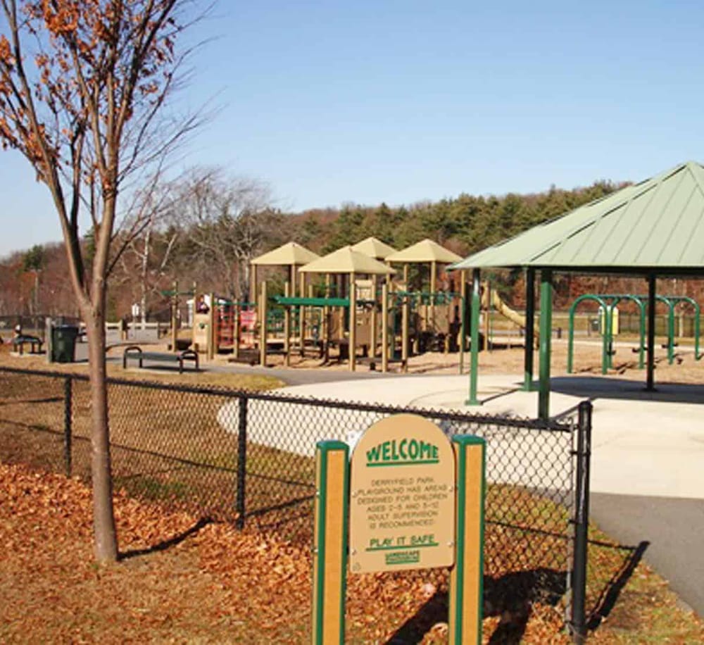 Bright playground with safety fencing and shade structures for children's outdoor activities.