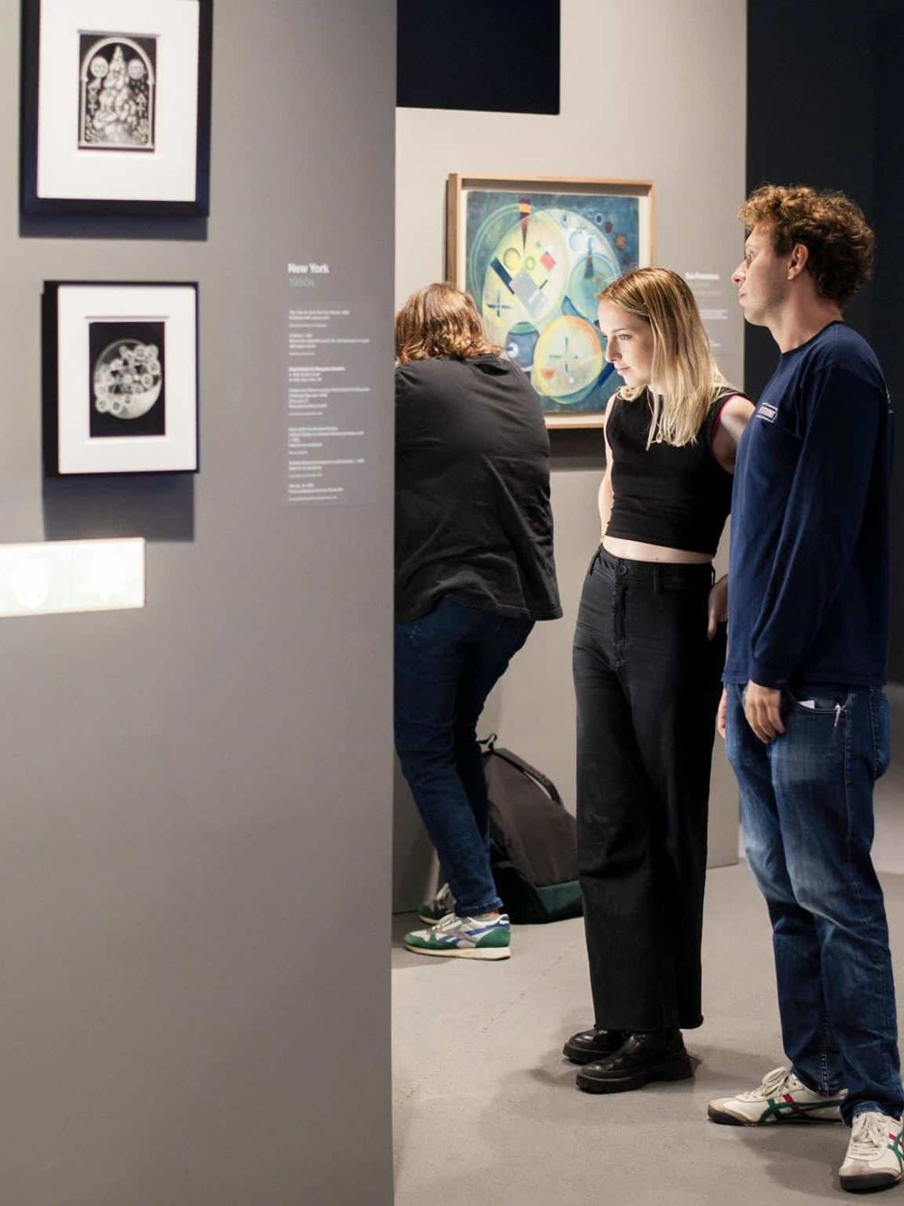 People viewing artwork in an art gallery or museum exhibition.