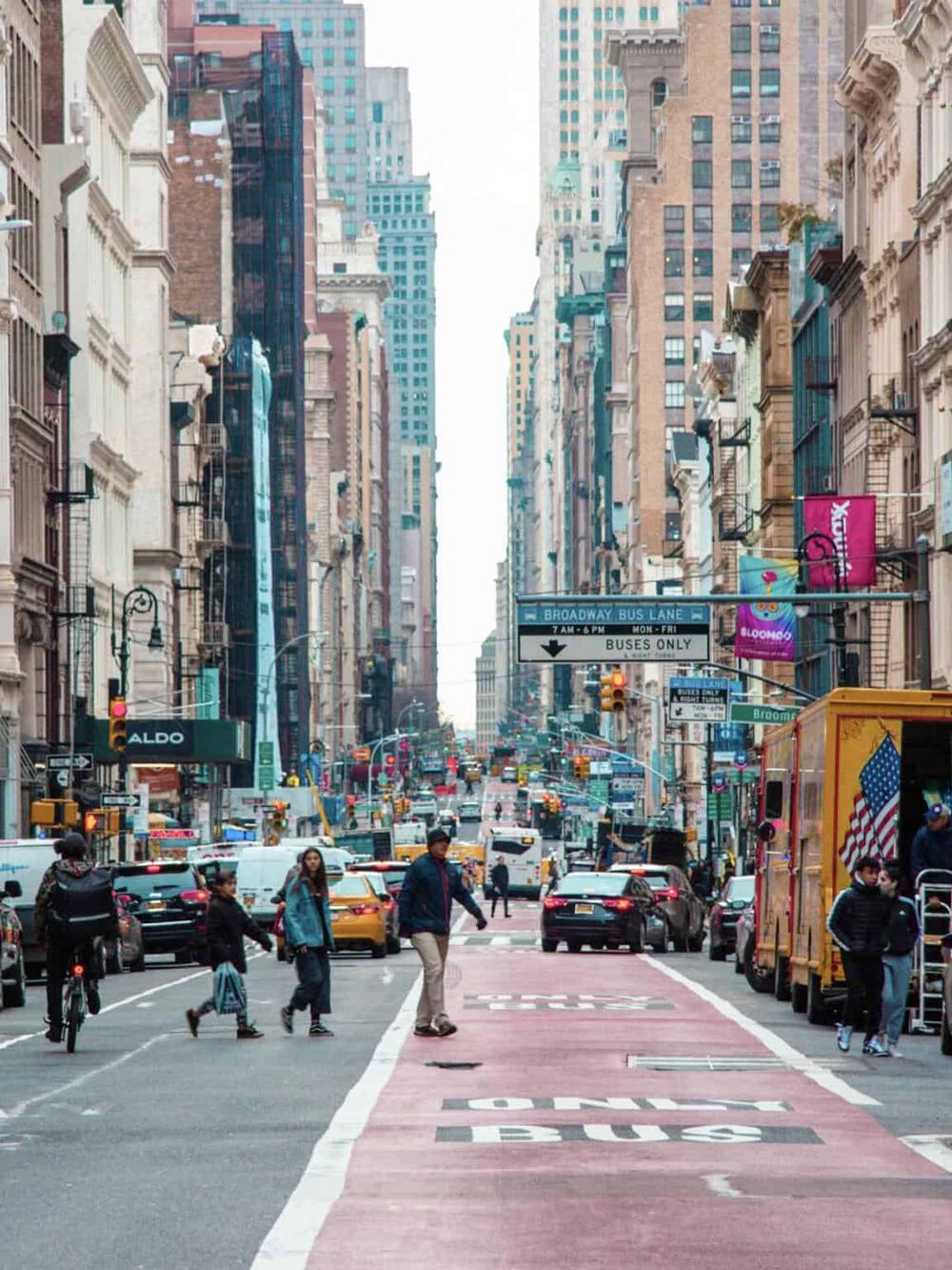 Bus lane New York City street with high-rise buildings and traffic flow for QuestForDirections SEO.