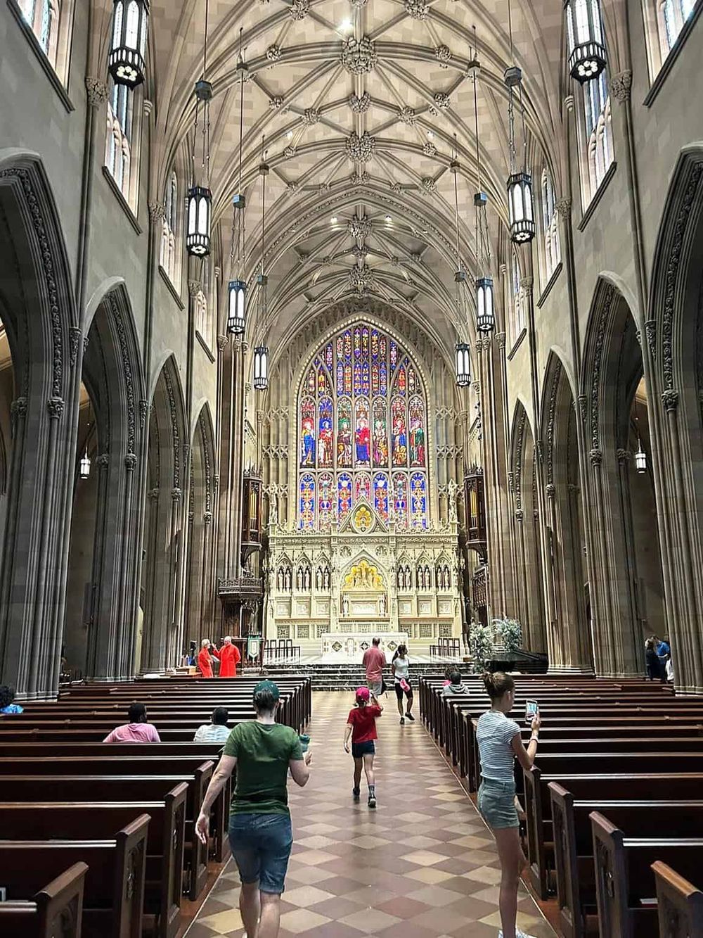 Stunning Gothic cathedral interior with intricate stained glass windows and high vaulted ceilings.