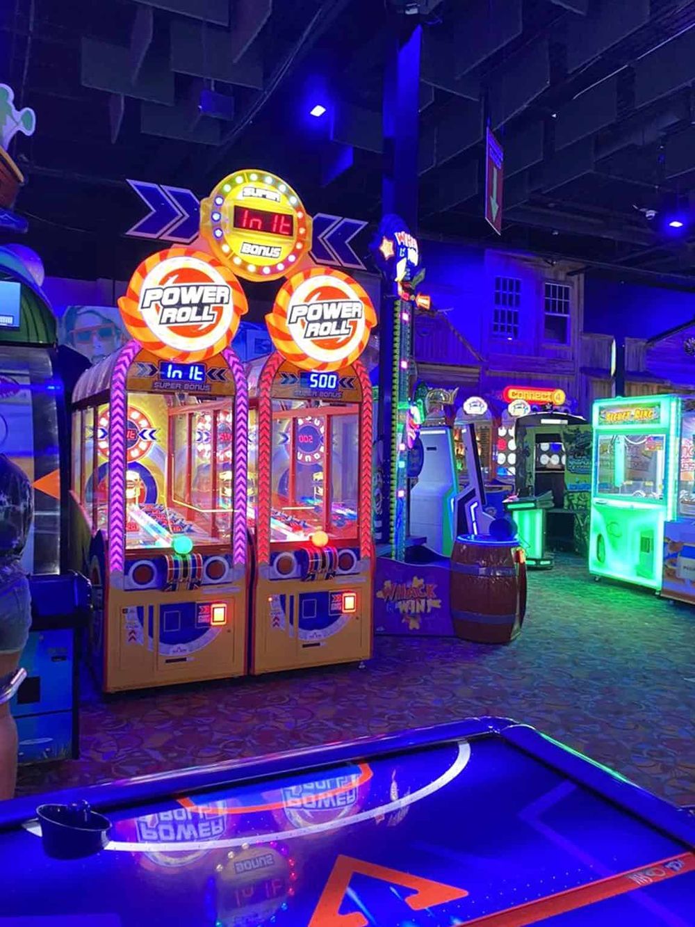 Bright arcade game machines with colorful lights at QuestForDirections amusement center.