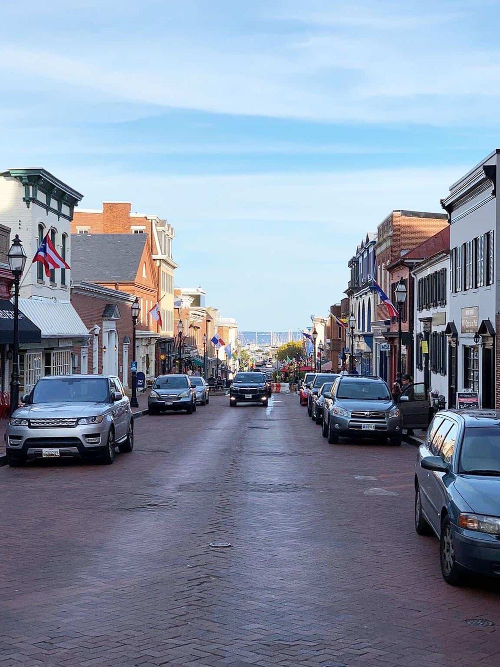 Charming downtown street view with colorful historic buildings and parked cars, showcasing a picturesque travel destination.