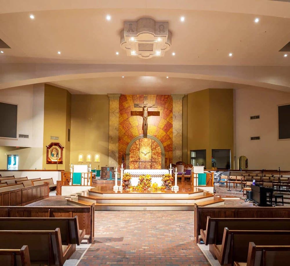 Spiritual church interior with altar, crucifix, candles, and worship seating for prayer and community services.