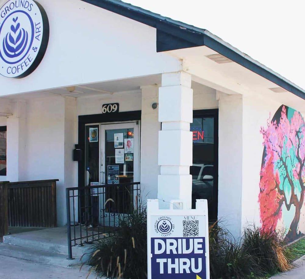 Coffee shop drive-thru with vibrant mural and outdoor sign, convenient location for quick orders.