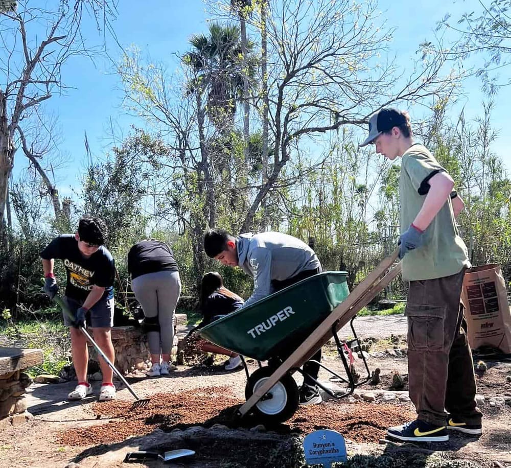 Students planting a tree for community service and environmental conservation.