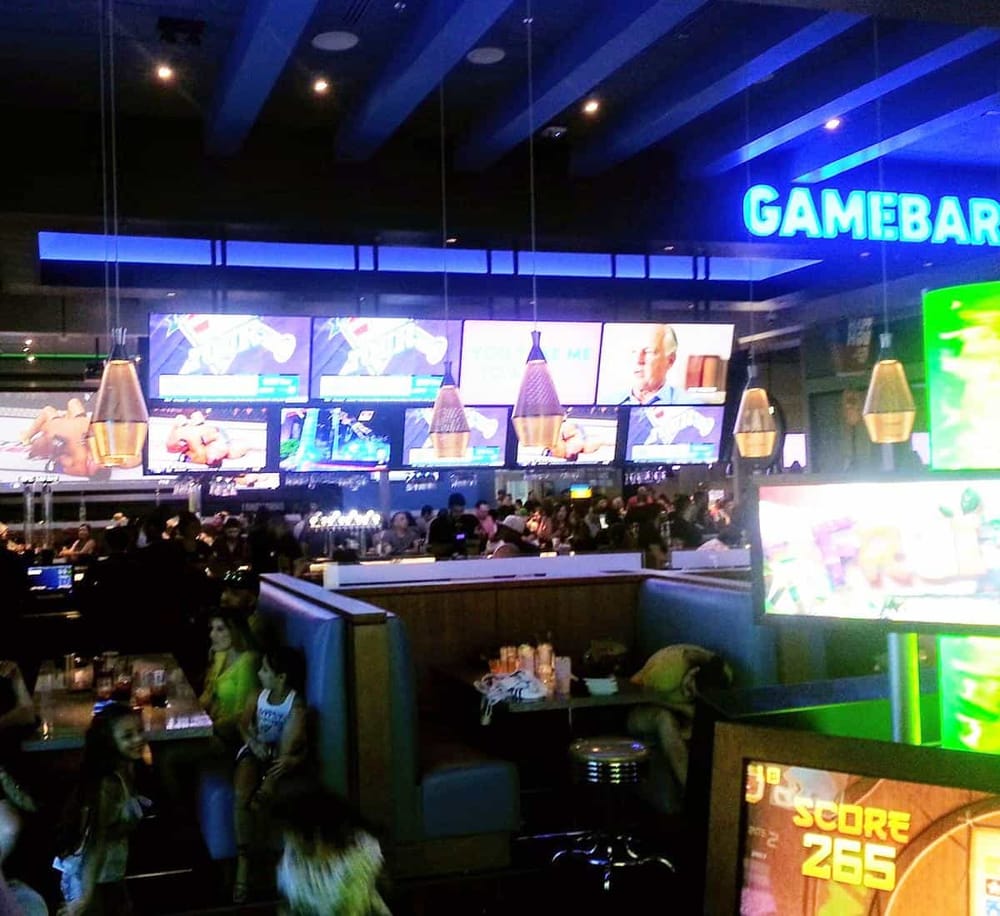 Bright game bar with multiple screens and lively atmosphere, perfect for gaming and entertainment.