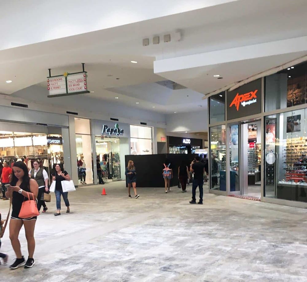 Shopping mall with retail stores and shoppers, QuestForDirections interior view.