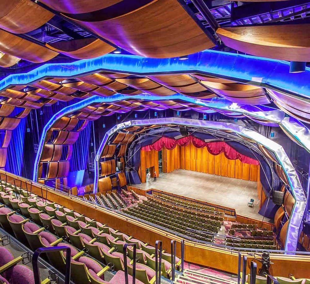Vibrant theater interior with modern lighting, wood accents, and spacious seating for live performances.