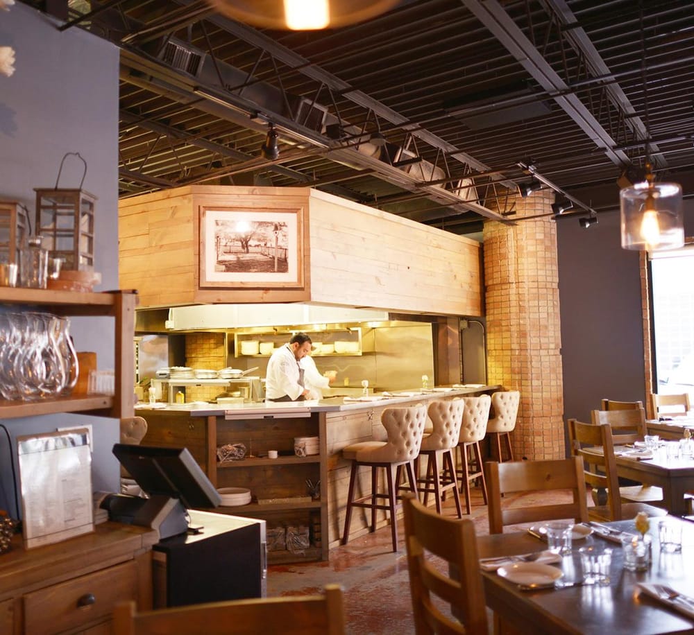 Cozy restaurant interior with open kitchen and warm lighting at QuestForDirections.