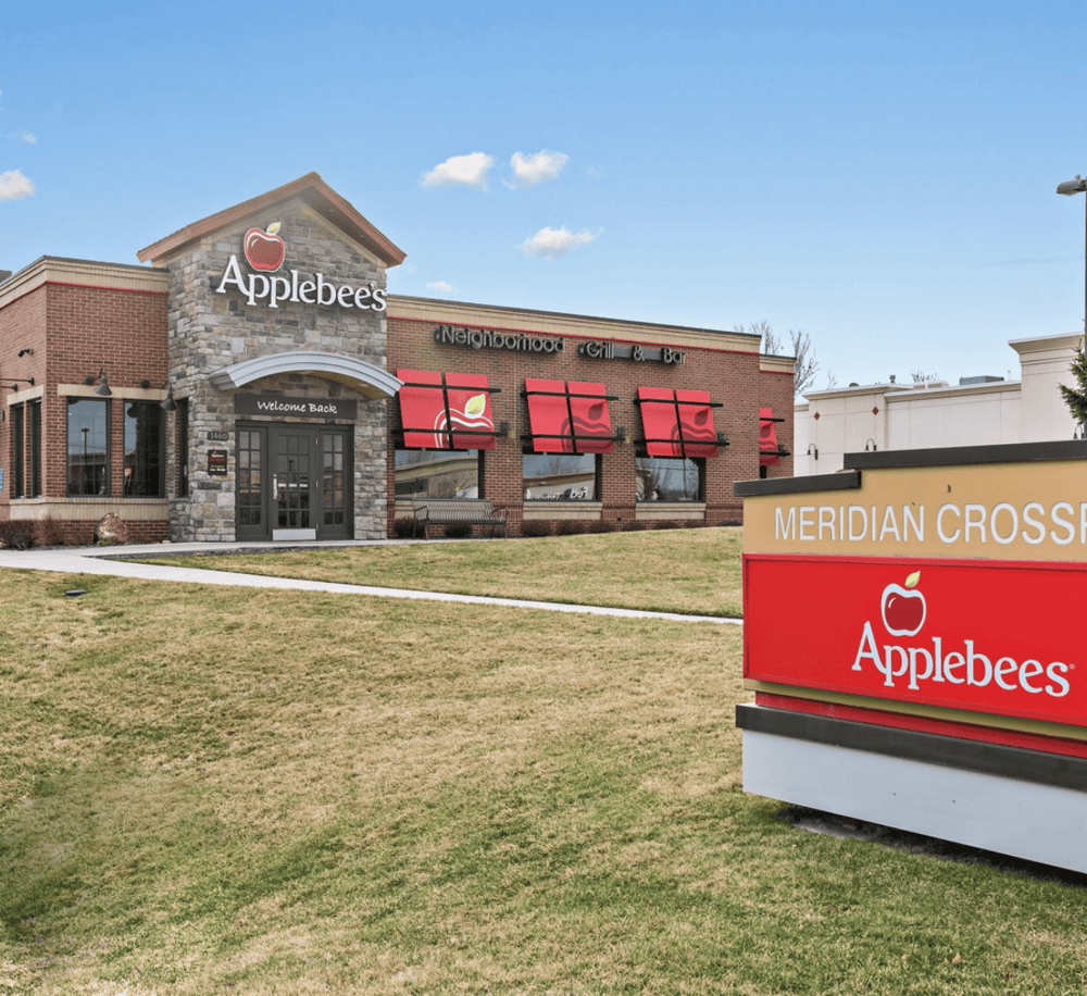 Applebee's restaurant exterior in a shopping center with Quest for Directions signage.