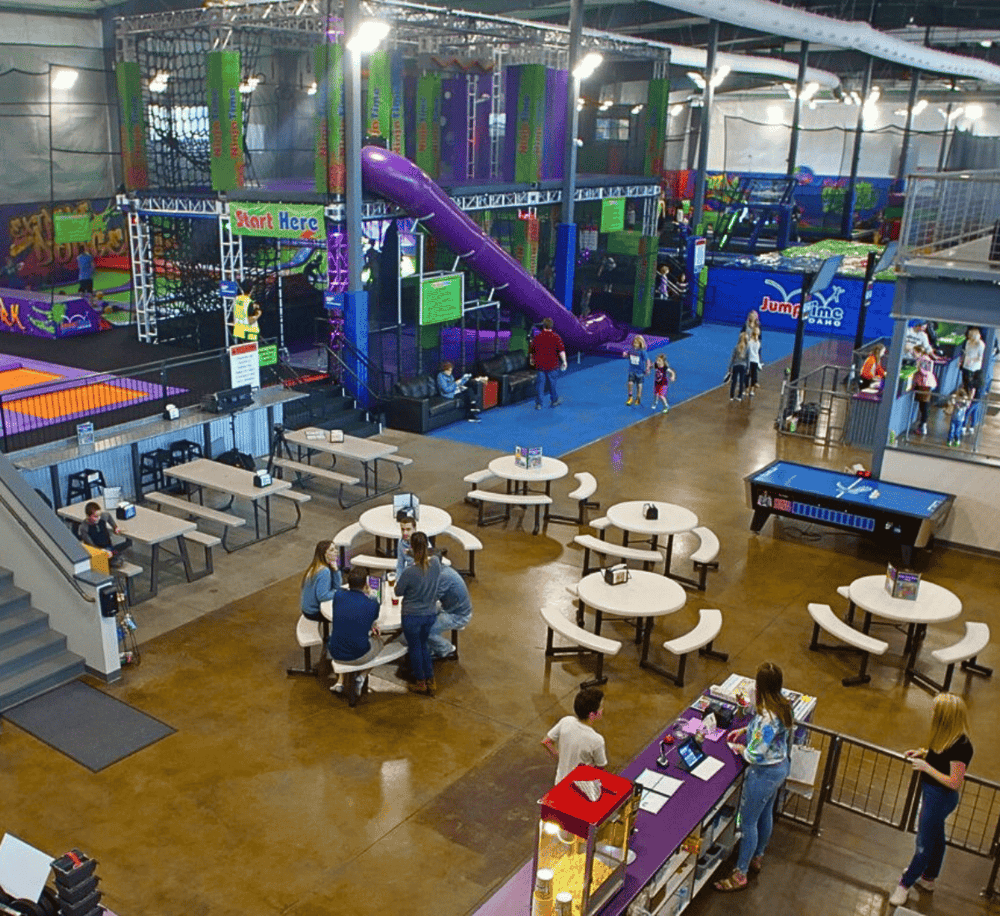 Indoor trampoline park with kids playing and adults relaxing at QuestForDirections. Family-friendly entertainment and fun activities.