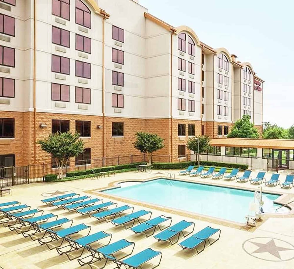 Modern hotel with outdoor pool and sun loungers for relaxation.