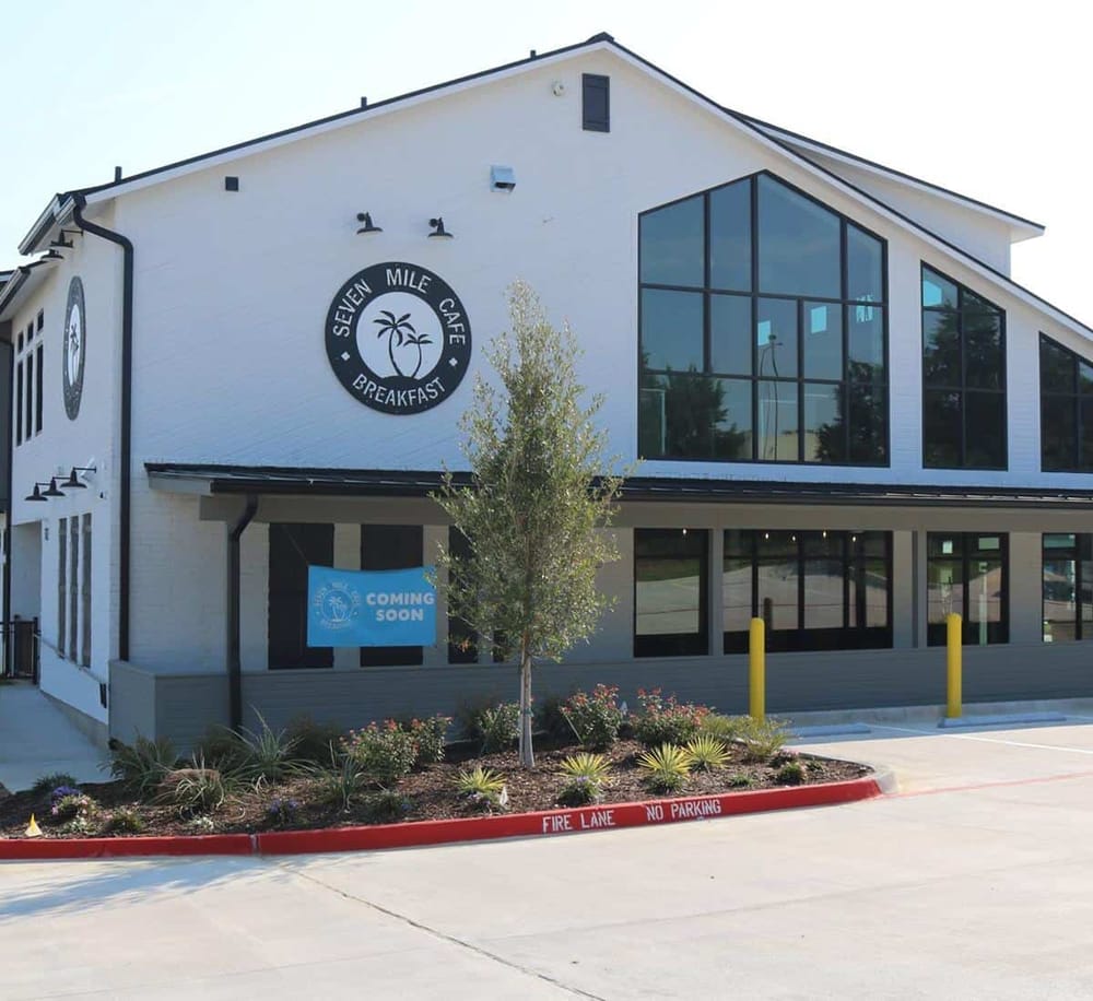 Modern café building with large glass windows and a "Coming Soon" sign, part of the Quest for Directions project.