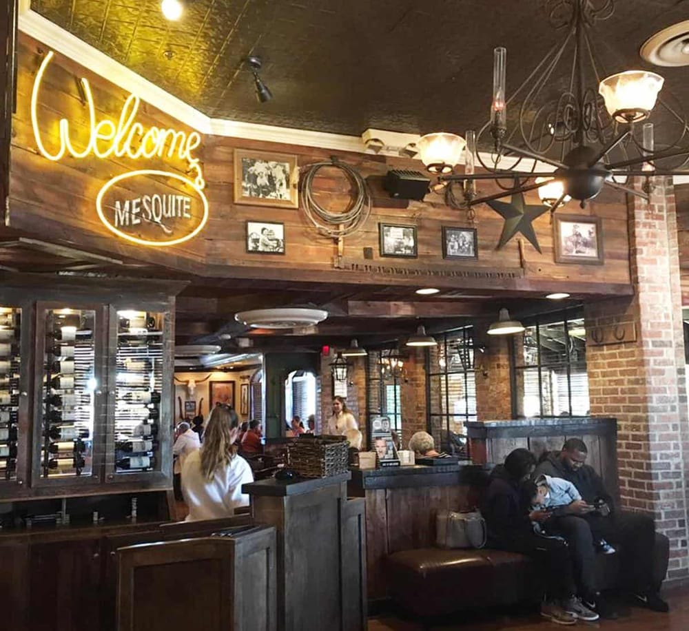 Welcoming interior of a cozy rustic restaurant or bar with vintage decor and a "Welcome" neon sign.