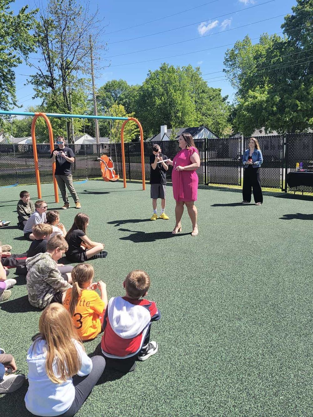 Outdoor kids' activity event at QuestForDirections, featuring children and teachers on a sunny day.