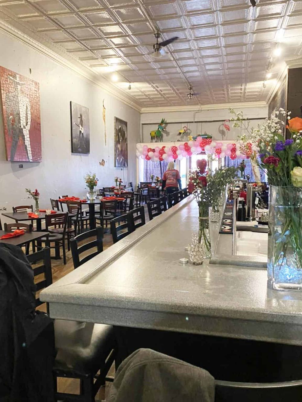 Brightly decorated restaurant interior with balloons and floral centerpieces, perfect for celebrations and events.