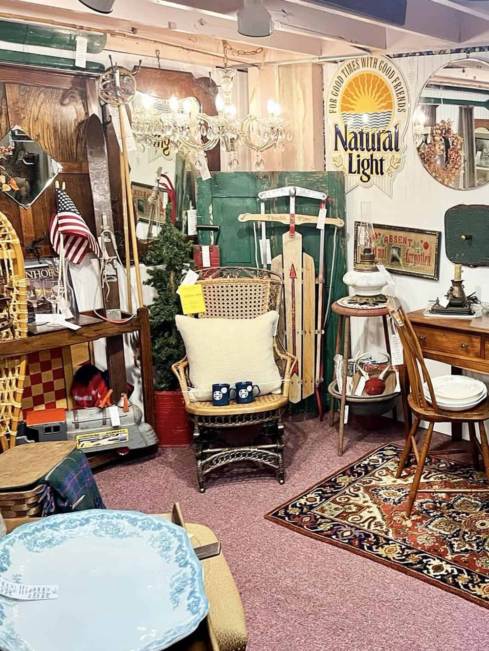 Vintage antique store with rustic furniture and decor, including chairs, lamps, and nostalgic signs. Ideal for furniture shopping and home decor.