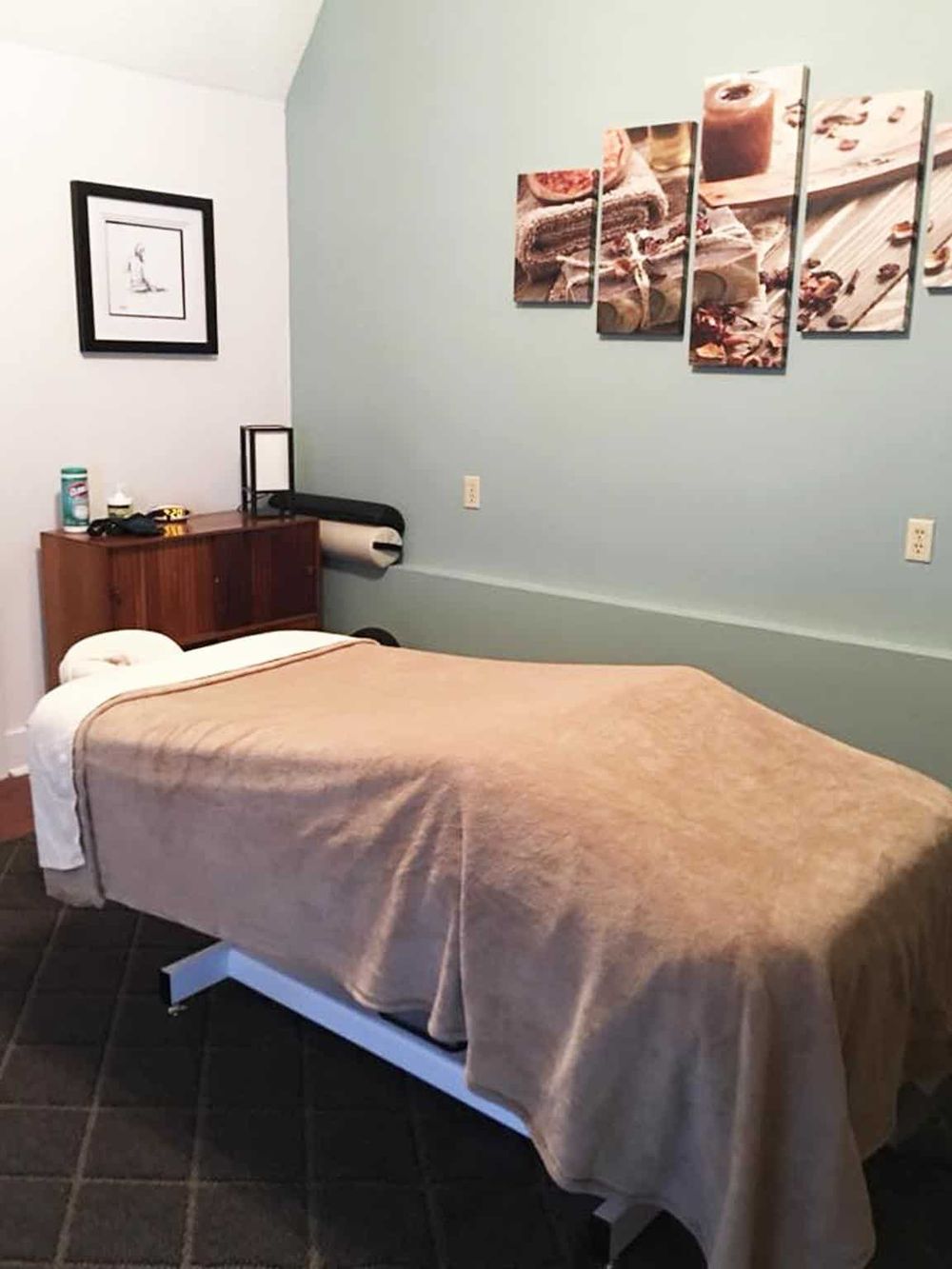 Comfortable hospital room with bed, wall art, and medical equipment for patient care.