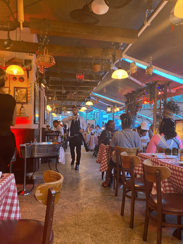 Elegant restaurant interior with friendly staff, vibrant lighting, and cozy atmosphere for dining experience.