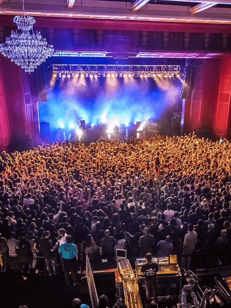 Vibrant concert crowd enjoying live music performance at indoor venue.