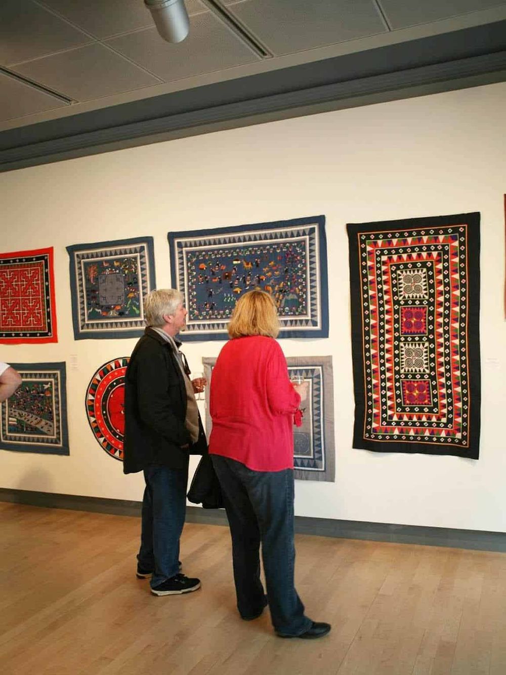 Colorful textile art exhibit at QuestForDirections gallery, showcasing vibrant, handcrafted tapestries and traditional patterns.