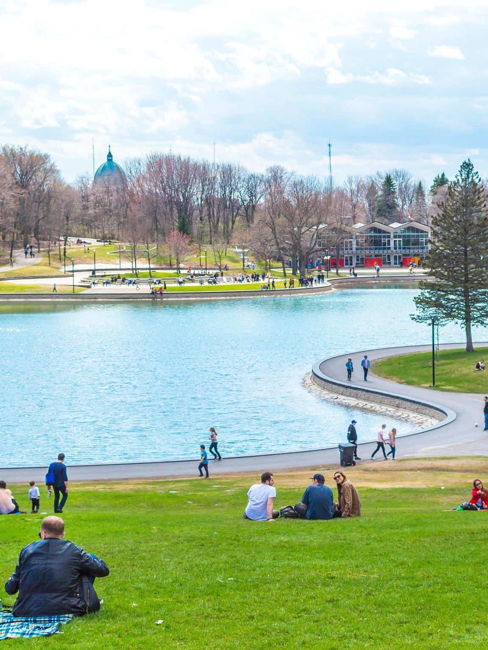 Beautiful park with a lake, walking paths, and people enjoying outdoor activities.