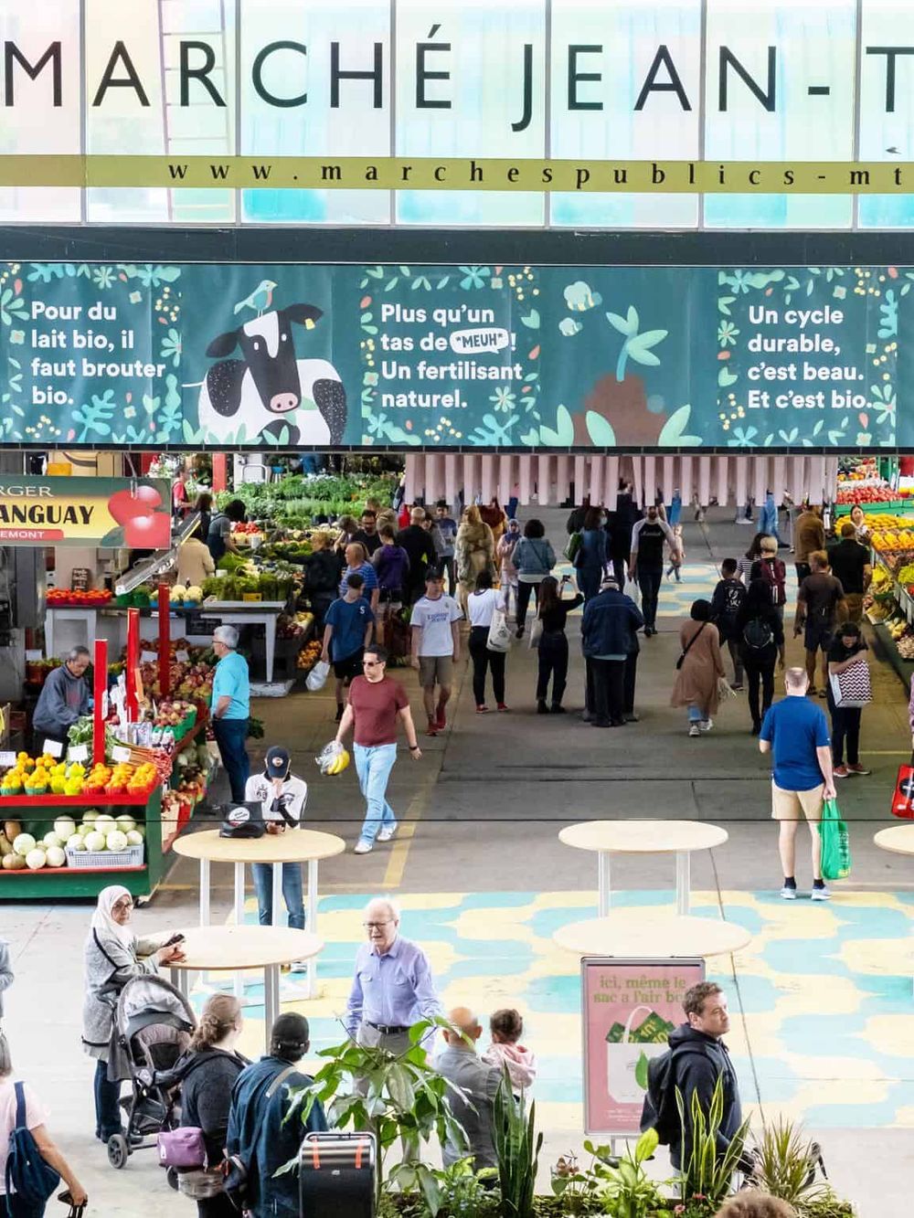 Organic Grocery Market in Marché Jean-Talon, Montreal indoor marketplace, bustling with shoppers and fresh produce.