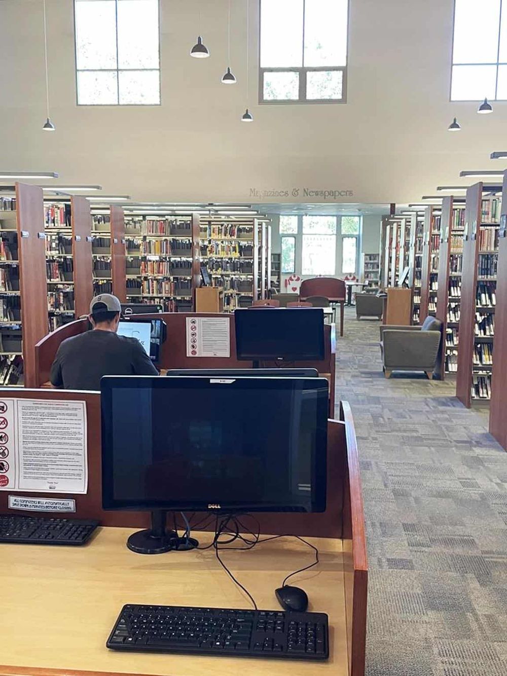 Quiet library with computer stations and bookshelves, ideal for research and studying.