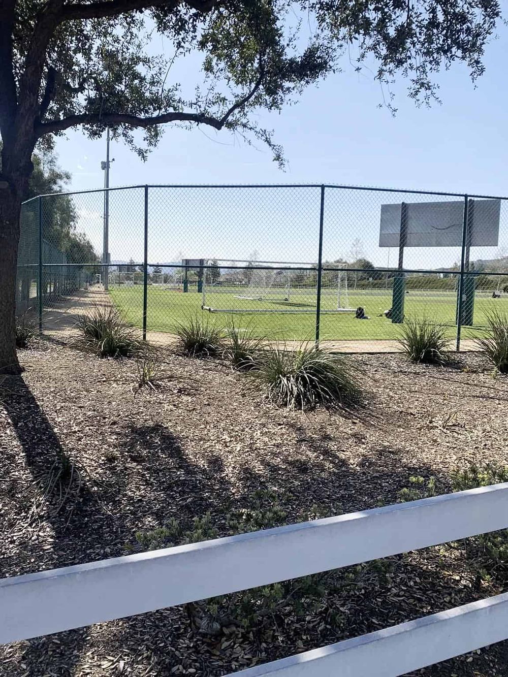 Athletic field enclosed with a chain-link fence for sports, exercise, and outdoor recreation activities.