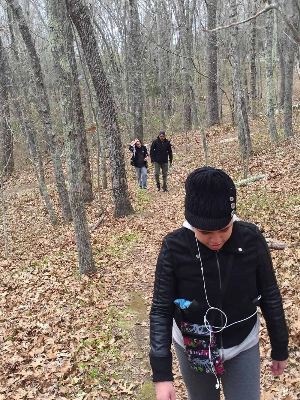 Walking on a trail in the woods during a team-building outdoor adventure at QuestForDirections.