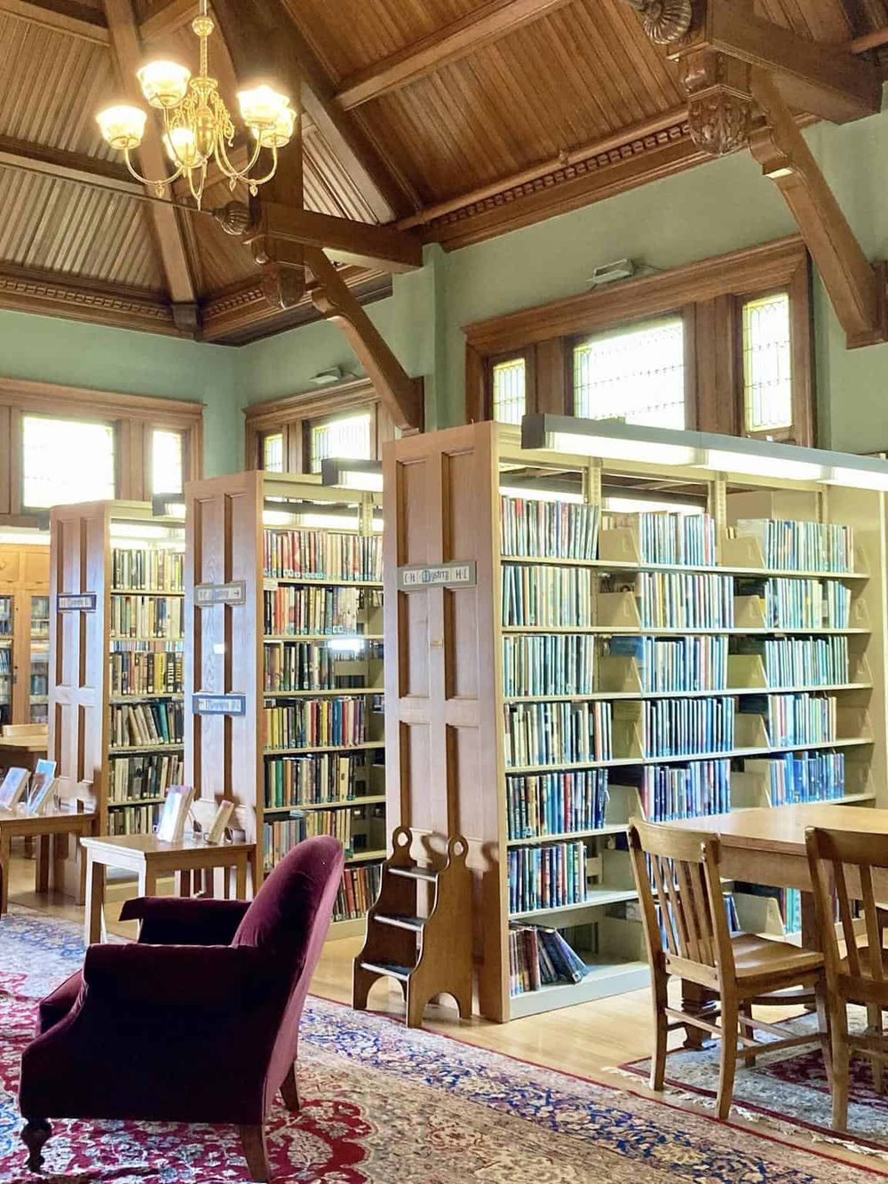 Cozy vintage library with wooden bookshelves, reading chairs, and classic decor for book lovers.