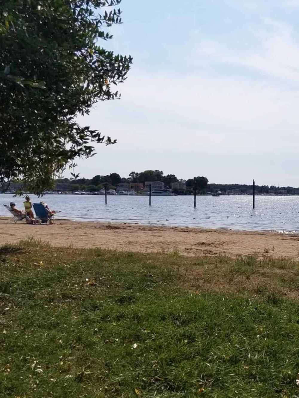 Relaxing lakeside beach scene with lounging chairs and scenic waterfront views.