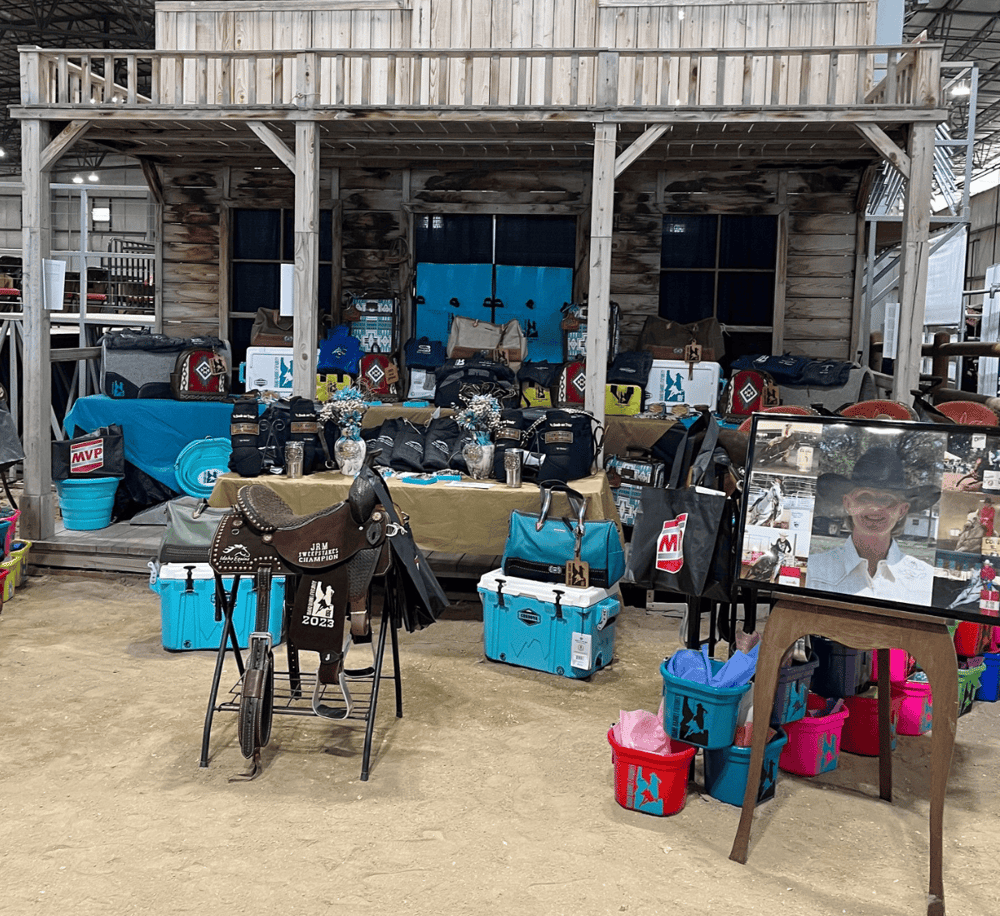 Blue outdoor gear and equipment display at cowboy-themed event.
