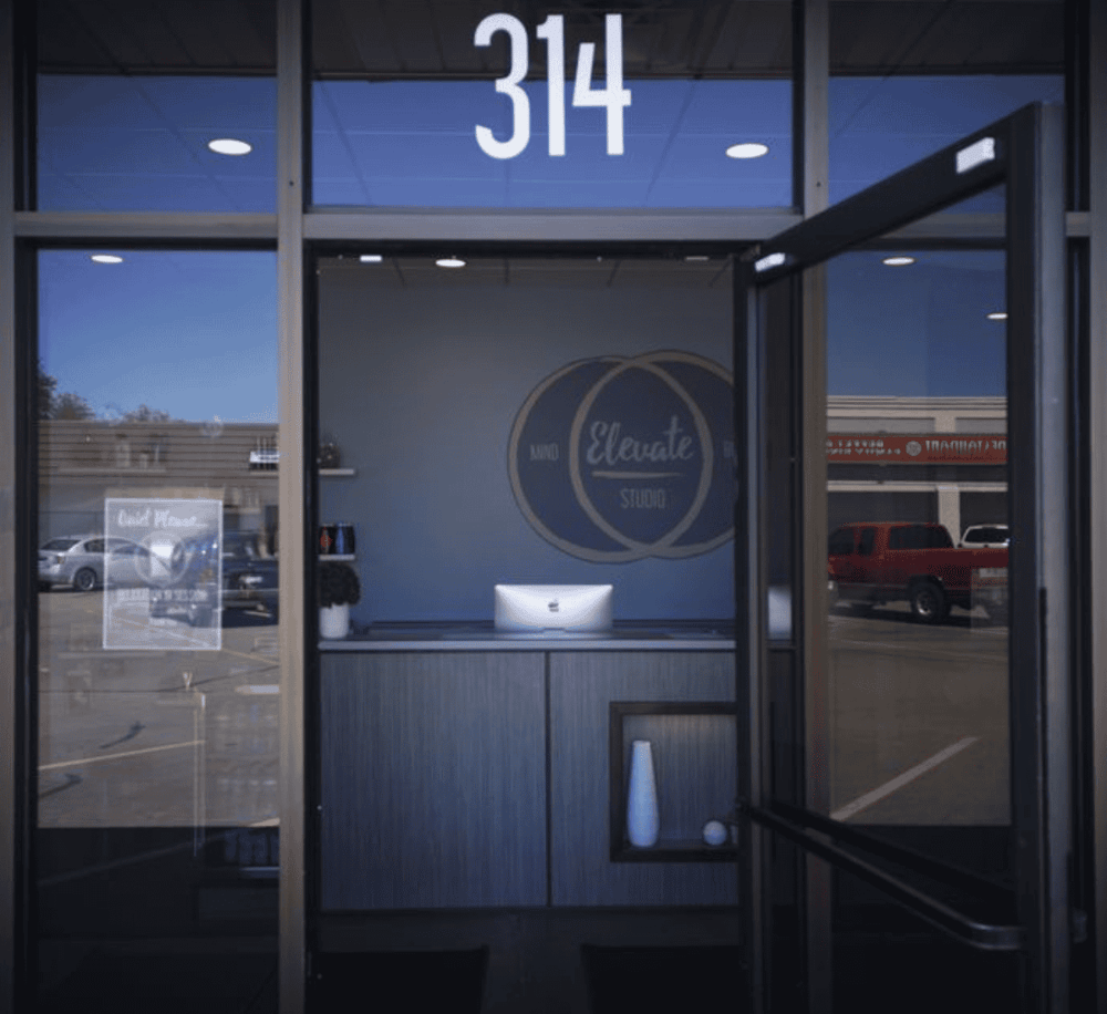 Modern interior reception area of QuestForDirections studio with clear glass doors and company logo.