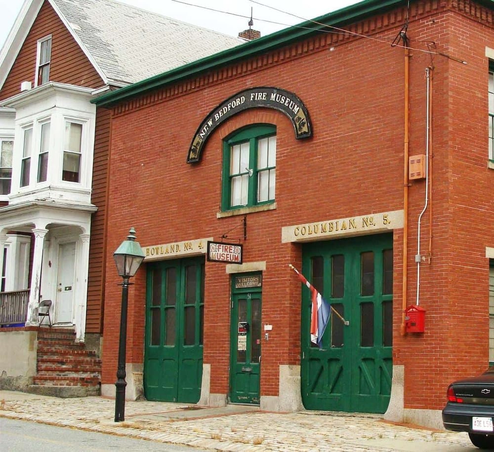 Historic Fire Museum building in Bedford, features red brick exterior and vintage firehouse doors.