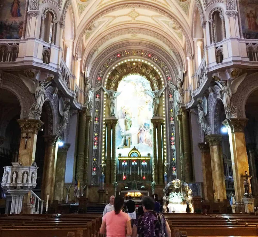 Intricate church interior with ornate architecture and religious statues, representing a sacred worship space.