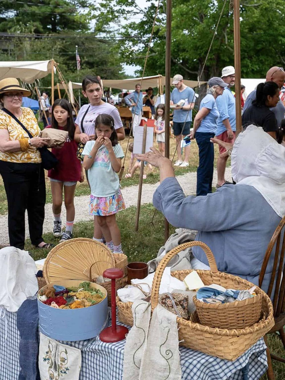 Colorful outdoor market with families and vendors, showcasing handcrafted goods and community engagement.