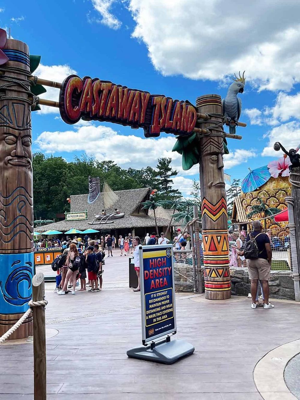 Colorful entrance to Castaway Island theme park with tropical decor and visitors waiting in line.