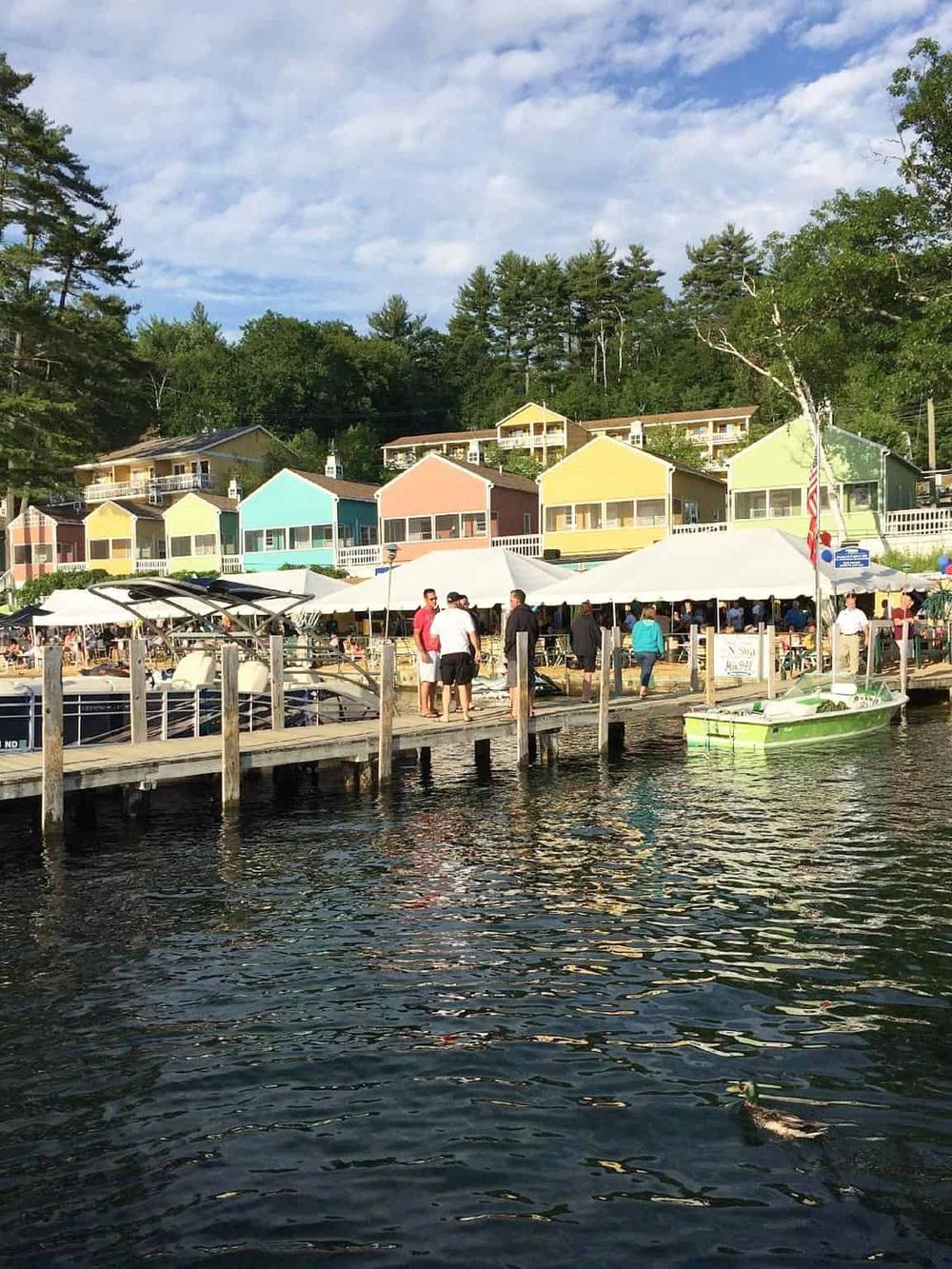 Colorful waterfront cottages and a lively dock scene with people enjoying a day by the water at QuestForDirections.