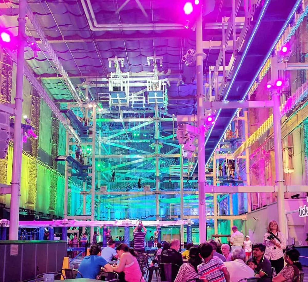 Colorful indoor adventure park with vibrant lighting and climbing structures for family entertainment and fun.