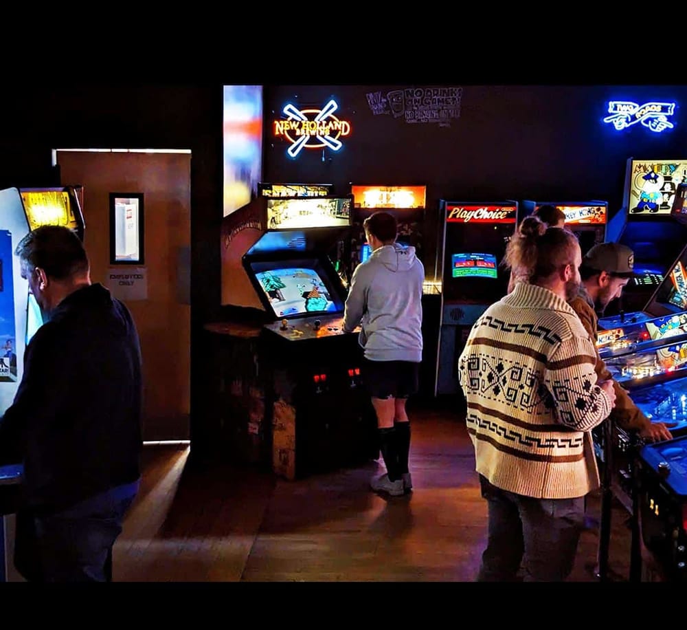 Old school arcade arcade games with neon lights and players.